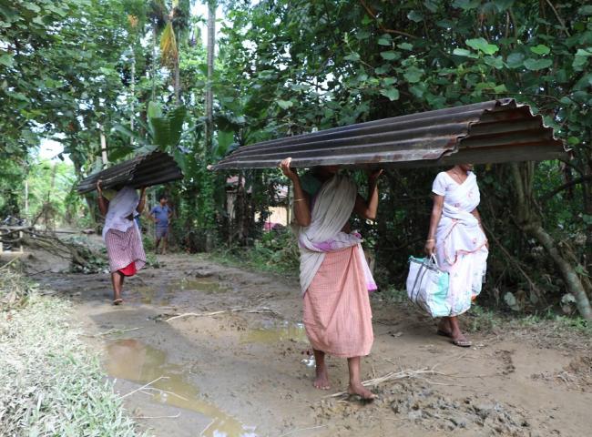 Fresh effort: Women heading home to build their ravaged homes afresh in Guri Jan Gohain Village, Gogamukh in Dhemaji District on Thursday. Photo by UB Photos