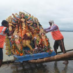 GMC worker carrying an idol of Goddess Durga for immersion in the Brahmaputra river on Bijoya Dashami at Kasomari Ghat in Guwahati on Saturday. Photo  by UB Photos