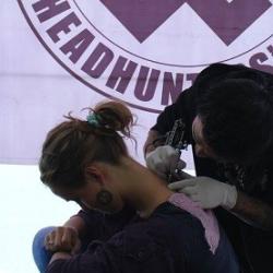 An artist tattoos Anne Torgod, a Norwegian tourist with a Naga tattoo